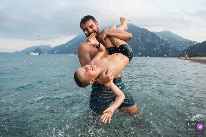 Père et fils jouent dans l'eau lors de leur voyage de camping en Turquie | Photojournalisme familial