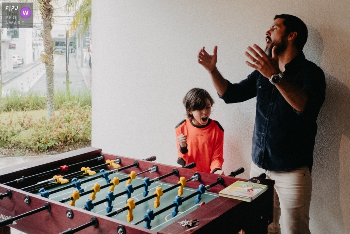 Father and son celebrating together after a game of foosball.