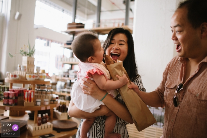 Photo by: <a href="https://www.fpja.com/documentary-family-photography-contests/tiffany-luong/los-angeles/2102734">Tiffany Luong - United States</a> California family photographer: baby grabs a baguette to her parents' surprise