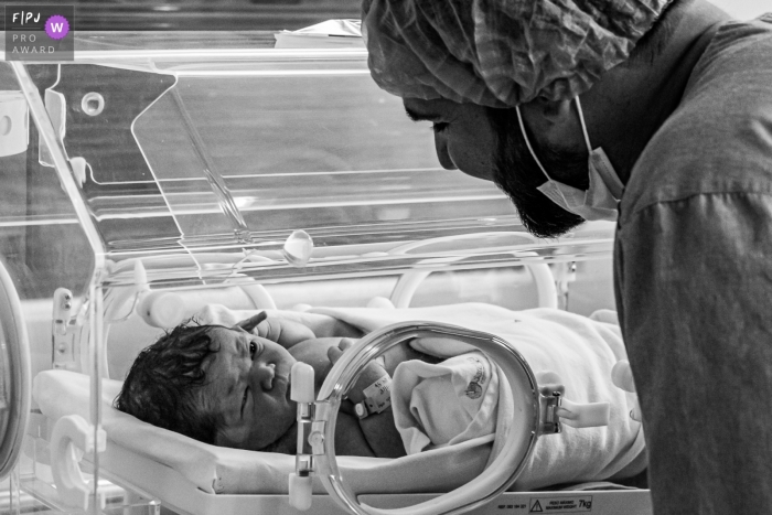 Rio de Janeiro Brésil, le bébé peu de temps après la naissance a dû rester dans l'incubateur de l'hôpital e Maternidade Santa Lúcia pendant que la mère recevait des soins spéciaux. Le père est resté proche comme s'il essayait de connaître ce petit être humain.