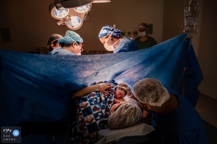 Le personnel de l'hôpital de Rio Grande do Sul travaille sur la mère pendant que papa et bébé profitent d'un nouveau moment.