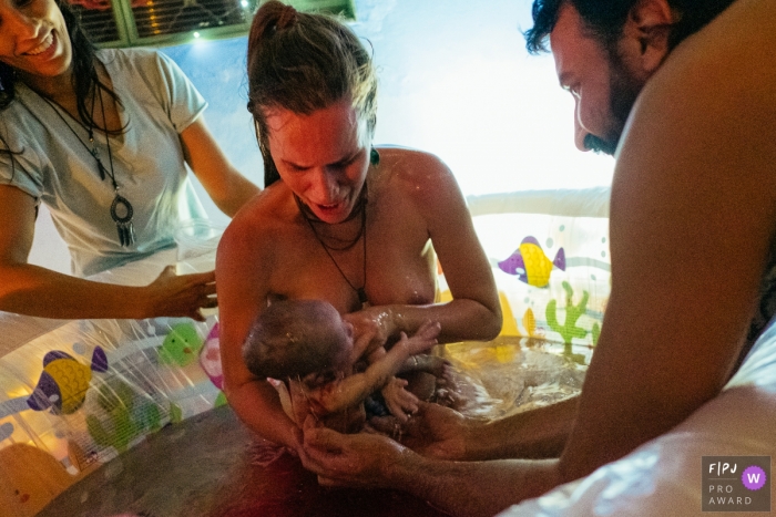 Photo by: <a href="https://www.fpja.com/documentary-family-photography-contests/marcos-paulo/sao-paulo/2104604">Marcos Paulo - Brazil</a> Sao Paulo Brazil dad helps during the delivery at a home water birth
