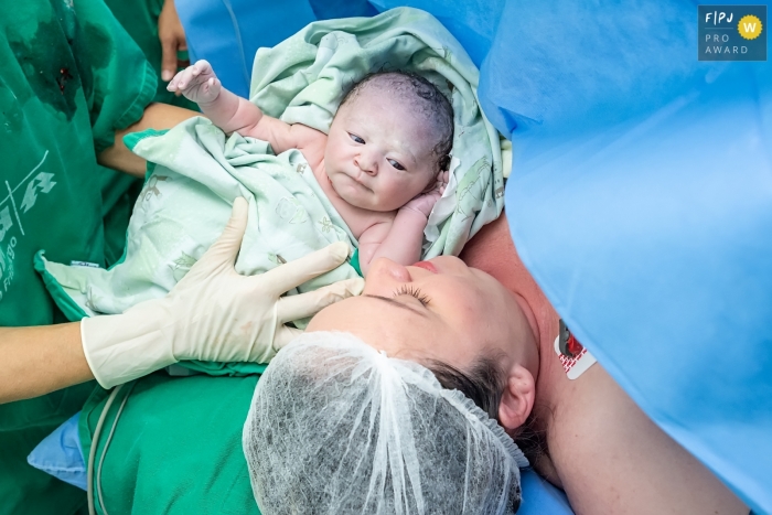 Photo by: <a href="https://www.fpja.com/documentary-family-photography-contests/gisele-soares/rio-de-janeiro/2104605">Gisele Soares - Brazil</a> Rio de Janeiro Brazil mother sees her newborn baby for the first time at Hospital Unimed