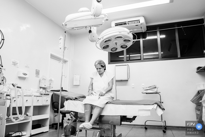 Photo by: <a href="https://www.fpja.com/documentary-family-photography-contests/gisele-soares/rio-de-janeiro/2104623">Gisele Soares - Brazil</a> Just before starting the preparations for surgery. The pregnant woman alone, thoughtful at Hospital Unimed in Nova Friburgo