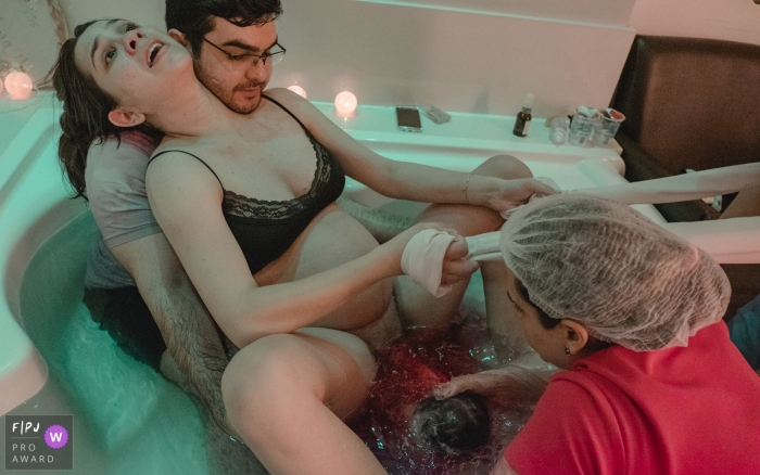 Photo by: <a href="https://www.fpja.com/documentary-family-photography-contests/lisandro-castro/cuiab%C3%A1/2104629">Lisandro Castro - Brazil</a> Hospital Santa Rosa bath birth image as the infant is coming into the world.