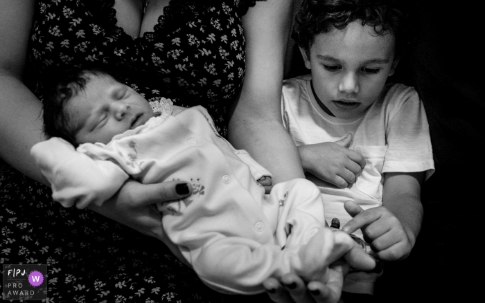 Photo by: <a href="https://www.fpja.com/documentary-family-photography-contests/lisandro-castro/cuiab%C3%A1/2104672">Lisandro Castro - Brazil</a> Mato Grosso brother checking out all the details of his new sister at Maternidade Femina
