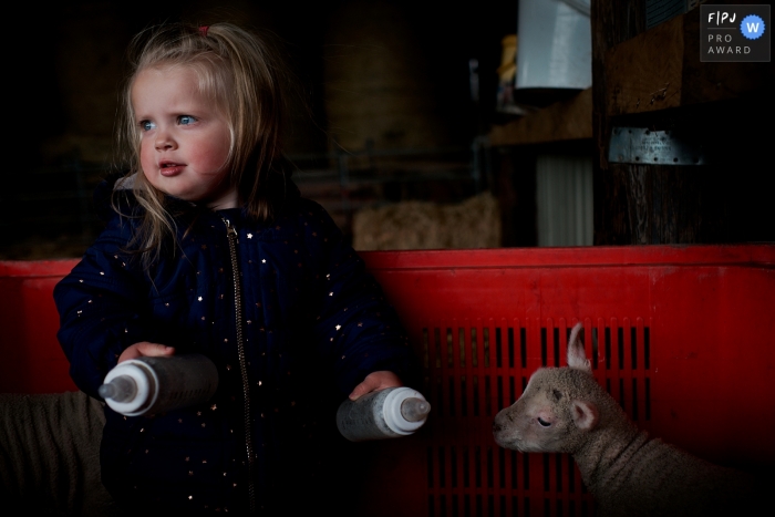 Photo by: <a href="http://fpja.com/documentary-family-photography-contests/william-bazlinton/dorset/2102863">William Bazlinton - United Kingdom</a> Dorset Family Photographer | Feeding the lambs in a crate on the family farm