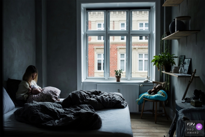 Photo by: <a href="https://www.fpja.com/documentary-family-photography-contests/frederikke-brostrup/copenhagen/2102987">Frederikke Brostrup - Denmark</a> A quite moment at home of a mother and her baby in Denmark.