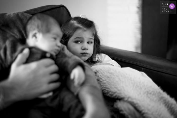 Photo by: <a href="https://www.fpja.com/documentary-family-photography-contests/melissa-ludwig/new-jersey/2103176">Melissa Ludwig - United States</a> New Jersey Sister looks at little brother skeptically