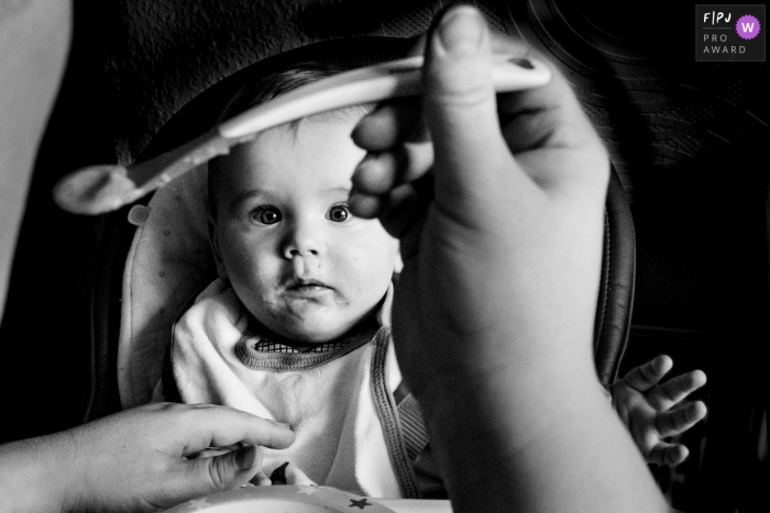 Reportage familial Aachen d'un jeune enfant qui regarde sa nourriture se dirige vers lui, nourri par sa mère.