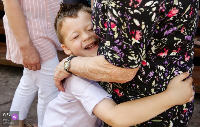 Photo by: <a href="https://www.fpja.com/documentary-family-photography-contests/ruthie-hauge/madison/2103547">Ruthie Hauge - United States</a> Madison Wisconsin boy takes a moment to hug his Grandmother between family portraits.