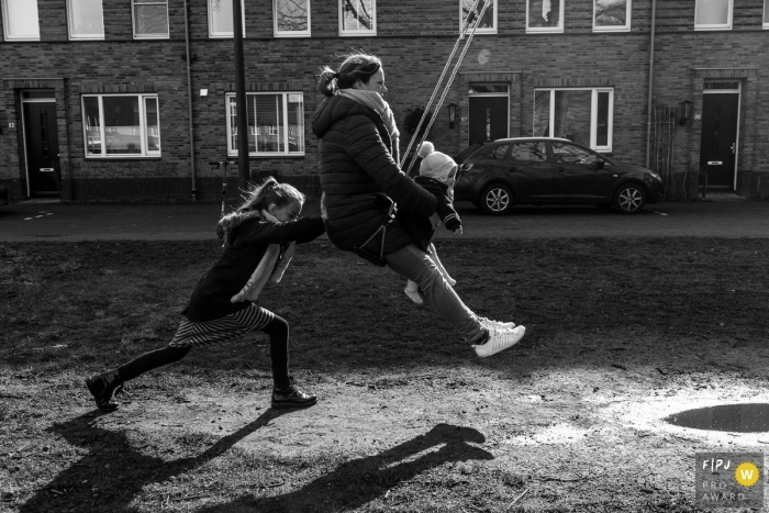 Photo by: <a href="https://www.fpja.com/documentary-family-photography-contests/lavinia-nitu/modena/2103605">Lavinia Nitu - Italy</a> Modena Emilia-Romagna Mother and 2 daughters are playing with the swing