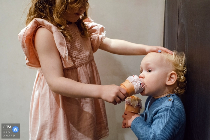 Photo by: <a href="https://www.fpja.com/documentary-family-photography-contests/laurie-peacock/chicago/2103675">Laurie Peacock - United States</a> Chicago siblings sharing ice cream - hold still