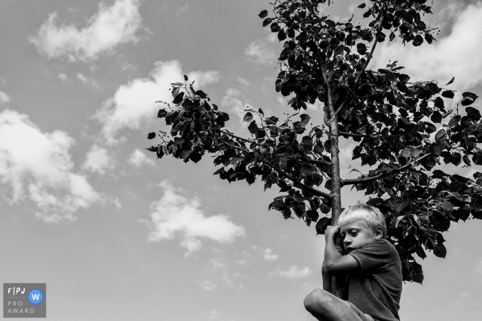 BW photo of a Flanders Child in tree while playing at home Flanders Child in tree while playing at home