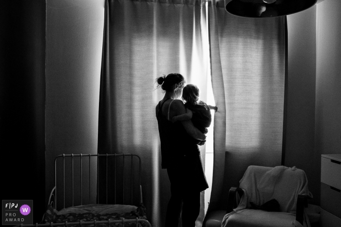 Photo by: <a href="https://www.fpja.com/documentary-family-photography-contests/ruth-wytinck/east-flanders/2103773">Ruth Wytinck - Belgium</a> East Flanders mom looking out the window - day in the life