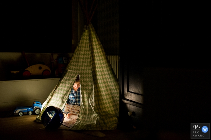 Photo by: <a href="https://www.fpja.com/documentary-family-photography-contests/ruth-wytinck/east-flanders/2103774">Ruth Wytinck - Belgium</a> East Flanders boy inside indoor tent during a day in the life session