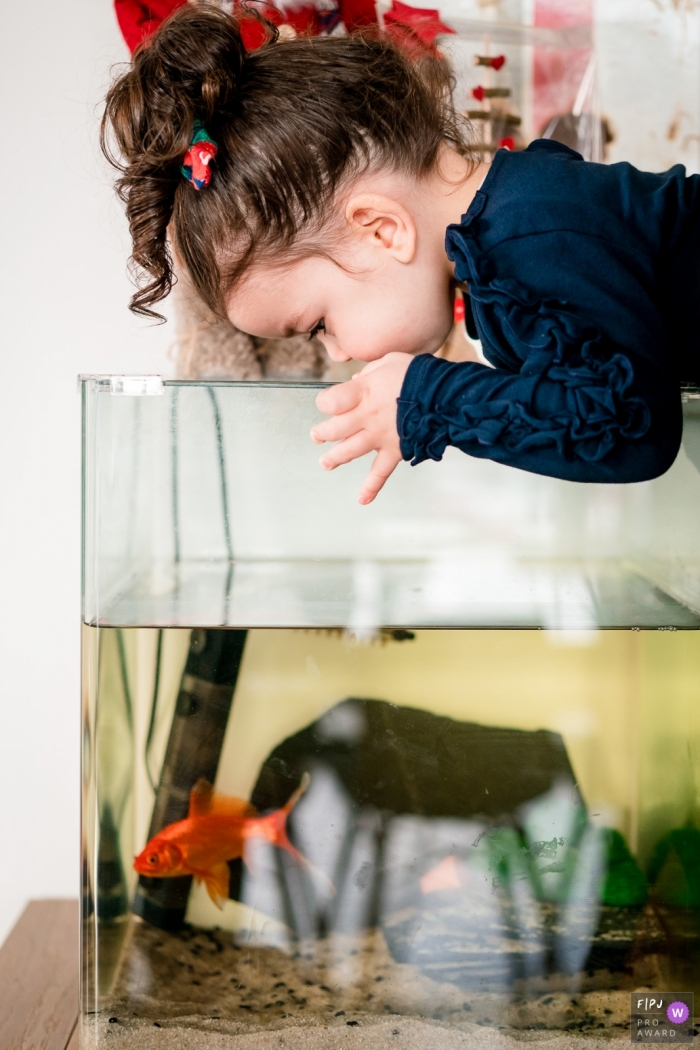 Photo by: <a href="https://www.fpja.com/documentary-family-photography-contests/sybil-rondeau/nantes/2103954">Sybil Rondeau - France</a> Nantes Loire-Atlantique little girl likes her fish in the tank at home