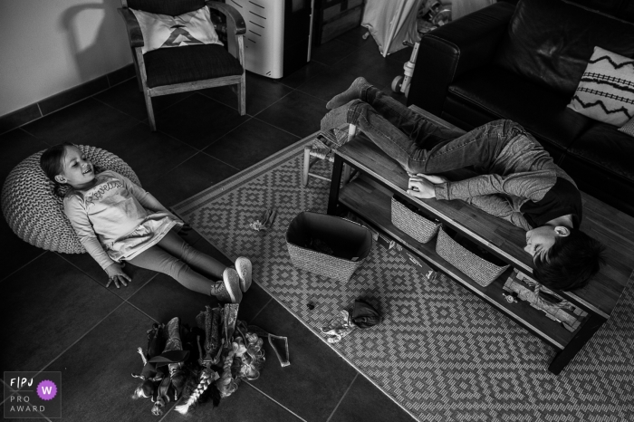 Photo by: <a href="https://www.fpja.com/documentary-family-photography-contests/nadine-court/savoie/2103992">Nadine Court - France</a> Savoie photo showing 2 children lying around in the living room