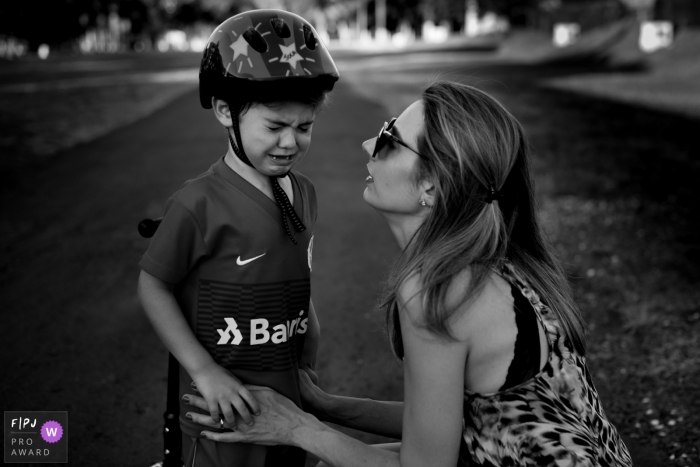 Photo by: <a href="https://www.fpja.com/documentary-family-photography-contests/morgana-secco/london/2104029">Morgana Secco - United Kingdom</a> London boy wearing a bicycle helmet is nurtured by his mother.