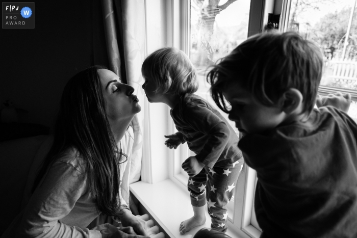 Cambridgeshire England Mum kisses toddler on window sill