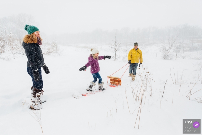 Madison Wisconsin Family of three takes a snowy walk. Girl pretends she's surfing. 