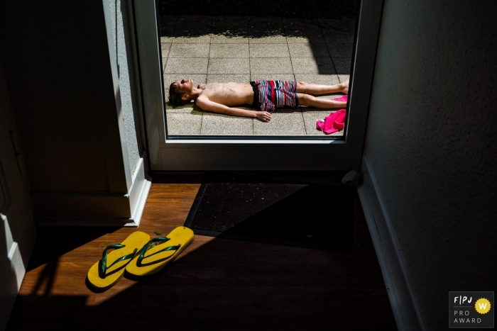 Photo by: <a href="https://www.fpja.com/documentary-family-photography-contests/katrin-k%C3%BCllenberg/dusseldorf/2104212">Katrin Küllenberg - Germany</a> Dusseldorf North Rhine-Westphalia young swimmer Drying in the sun