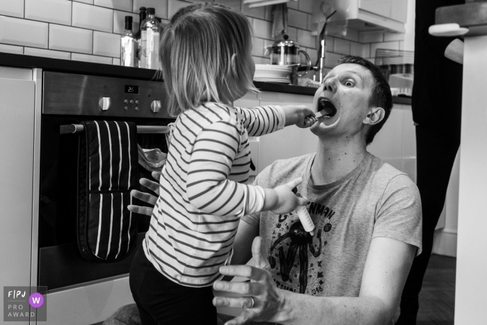 Photo by: <a href="https://www.fpja.com/documentary-family-photography-contests/linda-mauch/kent/2104294">Linda Mauch - United Kingdom</a> Kent England Little girl plays doctors with her Dad