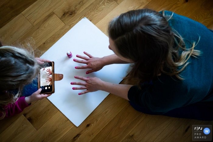 Photo by: <a href="https://www.fpja.com/documentary-family-photography-contests/linda-mauch/kent/2104308">Linda Mauch - United Kingdom</a> Kent England Daughter takes a picture of her mother's painted nails
