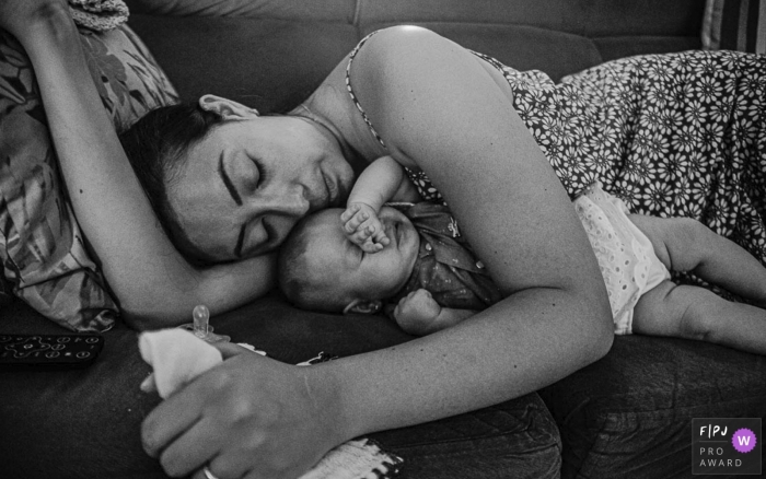 Photo by: <a href="https://www.fpja.com/documentary-family-photography-contests/lukinha-arruda/arapongas/2104449">Lukinha Arruda - Brazil</a> Arapongas Parana Mommy sleeping with the baby at home on the couch