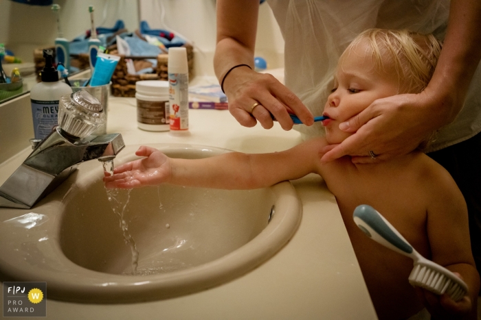 Photo by: <a href="https://www.fpja.com/documentary-family-photography-contests/julie-ambos/key-west/2104731">Julie Ambos - United States</a> Key West Florida child brushing teeth while getting ready for bedtime