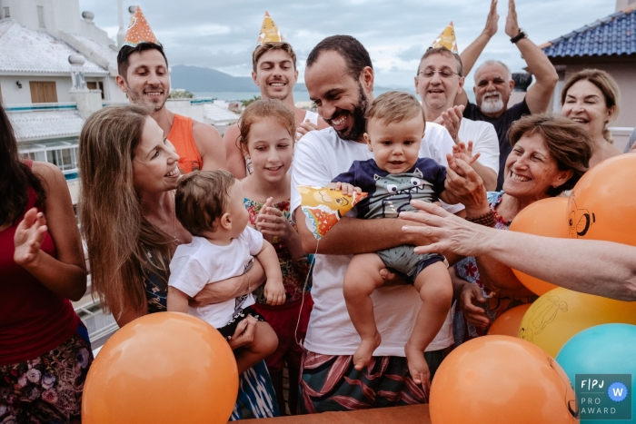 Photo by: <a href="https://www.fpja.com/documentary-family-photography-contests/thiago-braga/florianopolis/2104794">Thiago Braga - Brazil</a> Florianopolis Santa Catarina birthday party with balloons and family outside