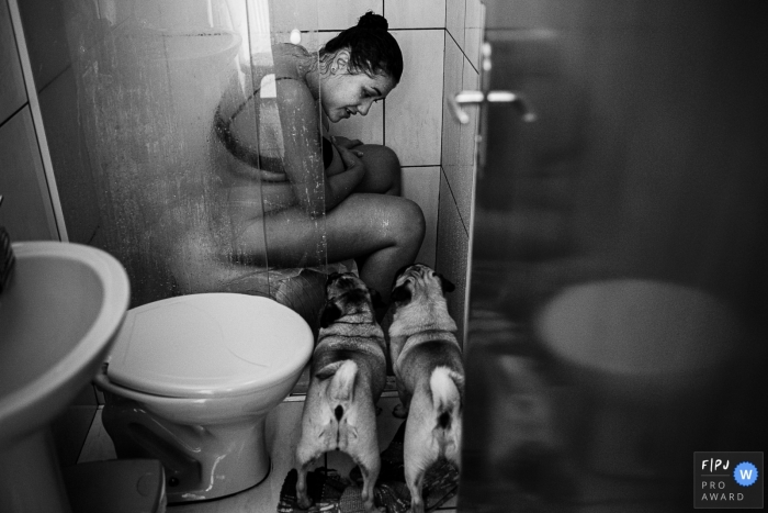Photo by: <a href="https://www.fpja.com/documentary-family-photography-contests/karoline-saadi/ribeirao-preto/2104982">Karoline Saadi - Brazil</a> Sao Paulo Natural Home Birth Photography from the Shower with two Dogs