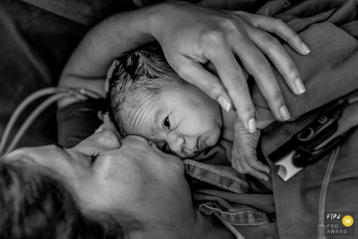 Photo by: <a href="https://www.fpja.com/documentary-family-photography-contests/eduardo-bedran/minas-gerais/2105489">Eduardo Bedran - Brazil</a> Mom gives her new baby his first kiss at the Materdei | Minas Gerais family and birth photographer