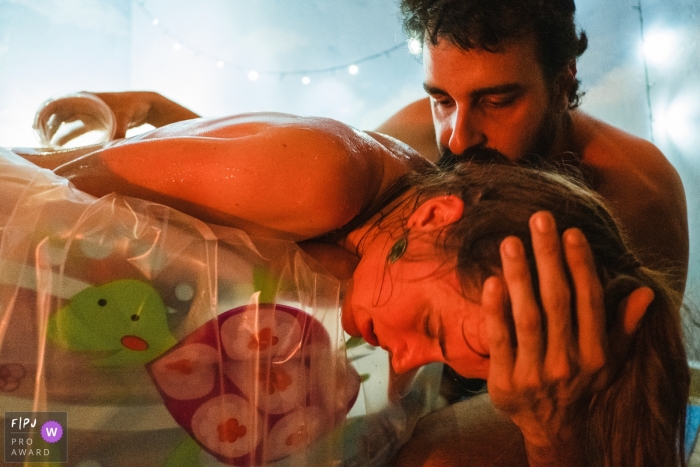 Photo by: <a href="https://www.fpja.com/documentary-family-photography-contests/marcos-paulo/sao-paulo/2105883">Marcos Paulo - Brazil</a> A husband gives his wife moral support as she is going through labor | Sao Paulo Birthing Photography