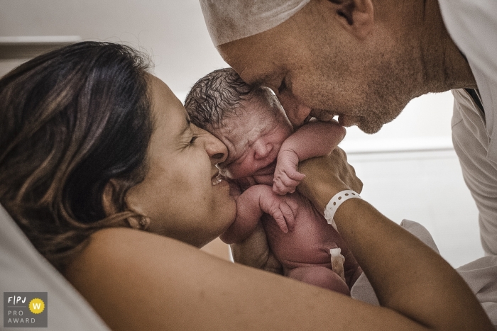 Photo by: <a href="https://www.fpja.com/documentary-family-photography-contests/clara-sampaio/rio-de-janeiro/2106267">Clara Sampaio - Brazil</a> Rio de Janeiro Brazil birth photography in hospital embracing the baby.