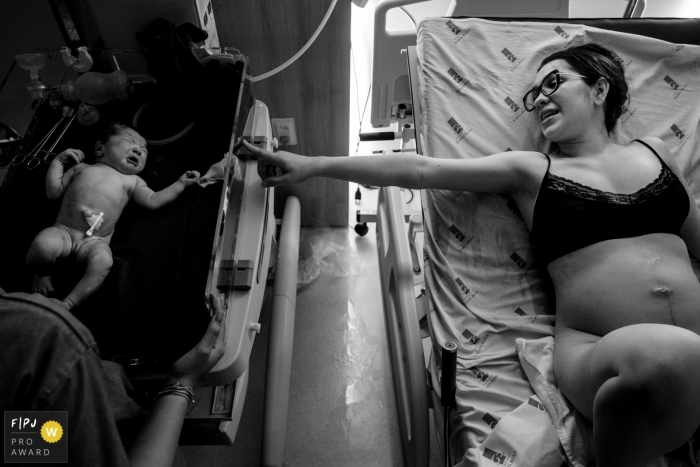 Photo par: Lisandro Castro - Brésil Une mère tend la main à son nouveau bébé sur un lit séparé à l'hôpital Santa Rosa au Brésil