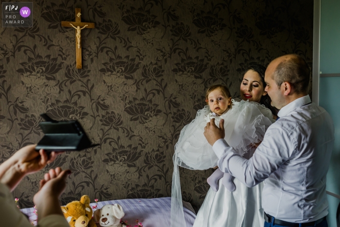Photo by: <a href="https://www.fpja.com/documentary-family-photography-contests/kobe-vanderzande/limburg/2104890">Kobe Vanderzande - Belgium</a> A young girl and family ready themselves for a baptism | Belgium baptism image