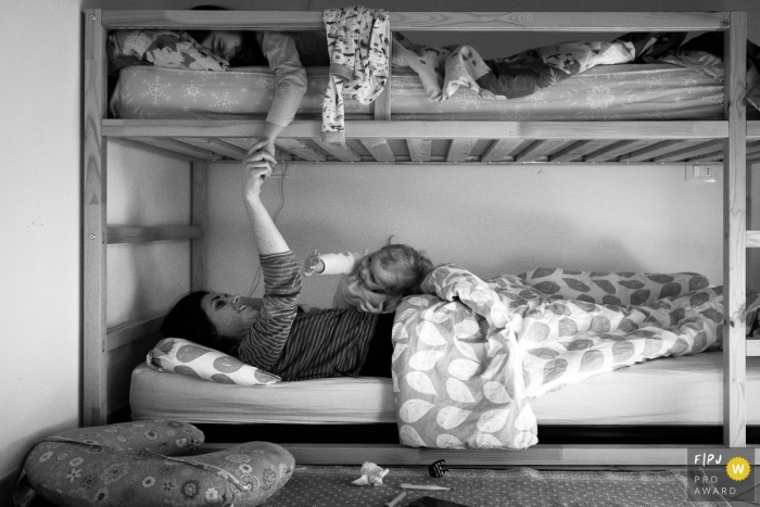 Photo by: <a href="https://www.fpja.com/documentary-family-photography-contests/lavinia-nitu/modena/2105052">Lavinia Nitu - Italy</a> The morning ritual when mom comes in to wake her kids up. | Italy day in the life family photography