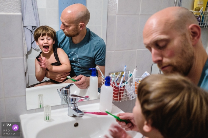 Photo by: <a href="https://www.fpja.com/documentary-family-photography-contests/jess-haverkamp/berlin/2105261">Jess Haverkamp - Germany</a> Dad waits patiently as routine of brushing teeth is never straightforward. | Germany day in the life family photography