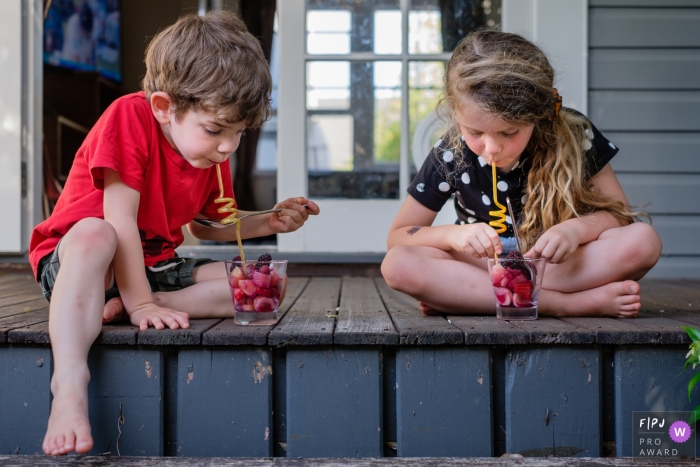 Photo by: <a href="https://www.fpja.com/documentary-family-photography-contests/jess-haverkamp/berlin/2105290">Jess Haverkamp - Germany</a> Berlin Germany Siblings relishing self-made dessert in family photo session