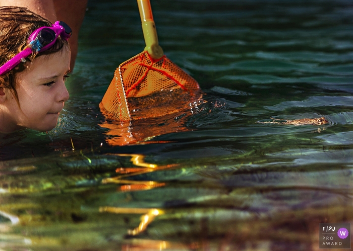 Un enfant trouve des grenouilles avec un filet dans un lac | Outer Banks, NC Photographe de famille