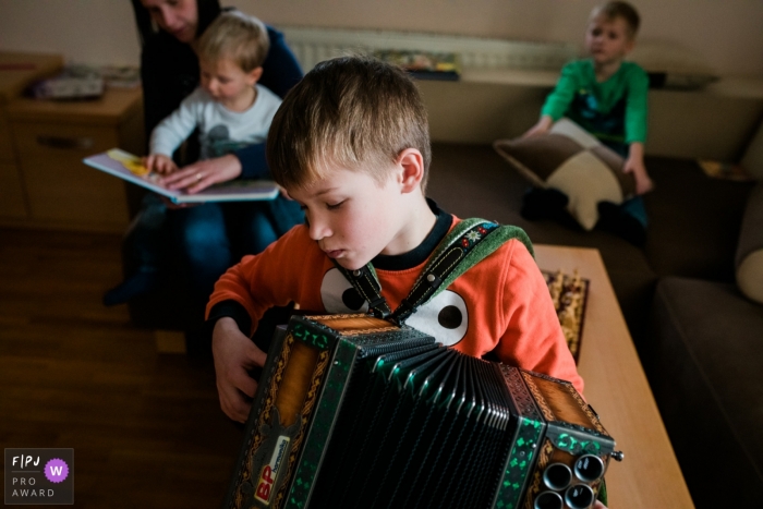 Un garçon aime pratiquer son accordéon | Photographie de la famille et des enfants de Ljubljana