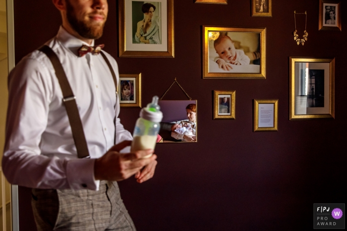 Photo by: <a href="https://www.fpja.com/documentary-family-photography-contests/indra-simons/overijssel/2106158">Indra Simons - Netherlands</a> A dad brings in milk for the newborn in their family. The baby can we seen in the mirror witht mom | Netherlands family photo