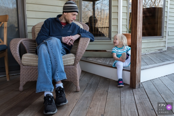Photo by: <a href="https://www.fpja.com/documentary-family-photography-contests/anna-holden/connecticut/2106592">Anna Holden - United States</a> Connecticut family photo session of dad and daughter sharing a moment on the porch.