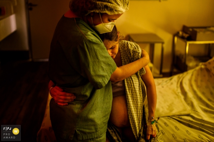 Photo by: <a href="https://www.fpja.com/documentary-family-photography-contests/priscilla-mondo/sao-paulo/2106674">Priscilla Mondo - Brazil</a> SÃO LUIZ ITAIM birth photo of mom being comforted during labor