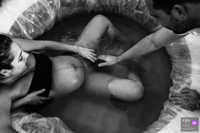 Photo by: <a href="https://www.fpja.com/documentary-family-photography-contests/marcos-paulo/sao-paulo/2107155">Marcos Paulo - Brazil</a> Sao Paulo birthing photo of Mother and Father touching their son