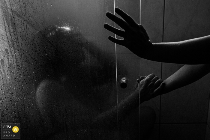 Photo by: <a href="https://www.fpja.com/documentary-family-photography-contests/marcos-paulo/sao-paulo/2107159">Marcos Paulo - Brazil</a> Sao Paulo Birthing picture of mother in labor in the shower, with a hand of help