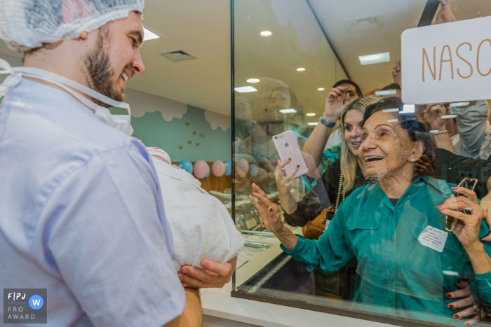 Photo by: <a href="https://www.fpja.com/documentary-family-photography-contests/cristiana-motta/orlando/2107391">Cristiana Motta - United States</a> Perinatal Laranjeiras Birth Photography | Visitors take a look at the new baby, grandma with the front row view