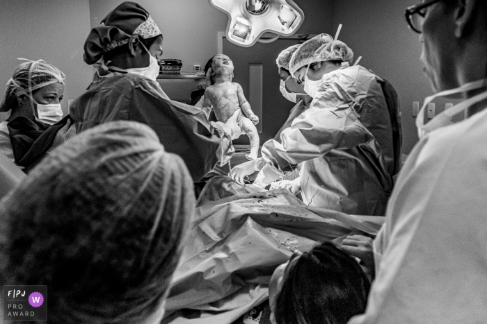 Photo by: <a href="https://www.fpja.com/documentary-family-photography-contests/liliane-cotta/rio-de-janeiro/2107800">Liliane Cotta - Brazil</a> Maternidade Perinatal birth photo of baby just born and parents are seeing it for the first time