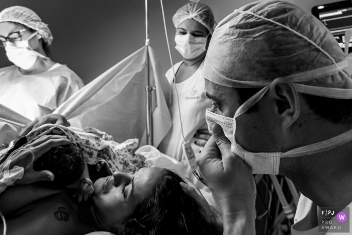 Photo by: <a href="https://www.fpja.com/documentary-family-photography-contests/liliane-cotta/rio-de-janeiro/2107822">Liliane Cotta - Brazil</a> Maternidade Perinatal Documentary Birth Photo | Father can't control emotion when he sees his daughter after his wife's long hours at birth